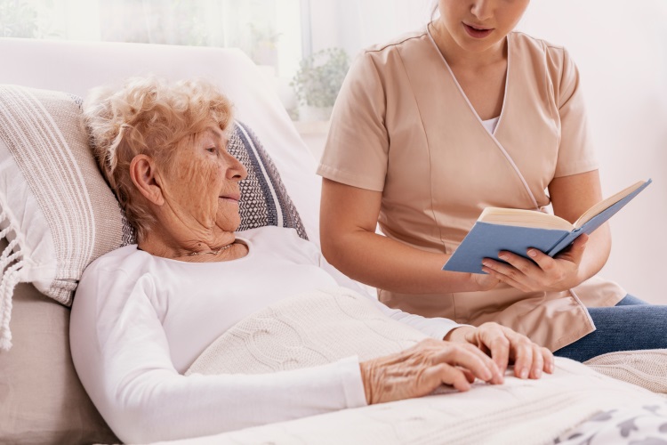 older woman being read to